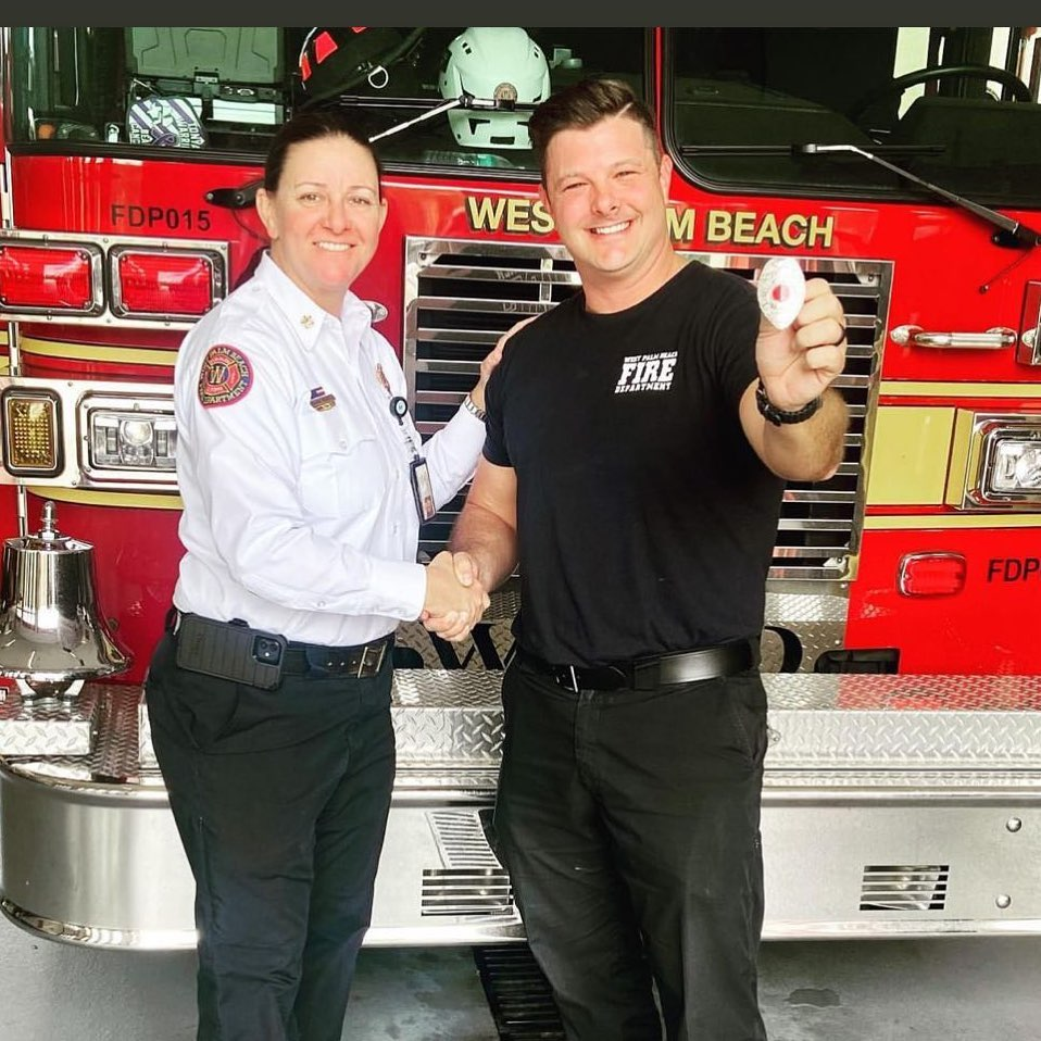 Ryan shaking hands with the chief in front of a West Palm Beach fire truck